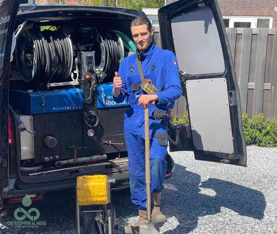 Een tevreden monteur met opgestoken duim naast de bestelbus, slim ingrijpen bespaart kosten bij een verstopte afvoer in Almere