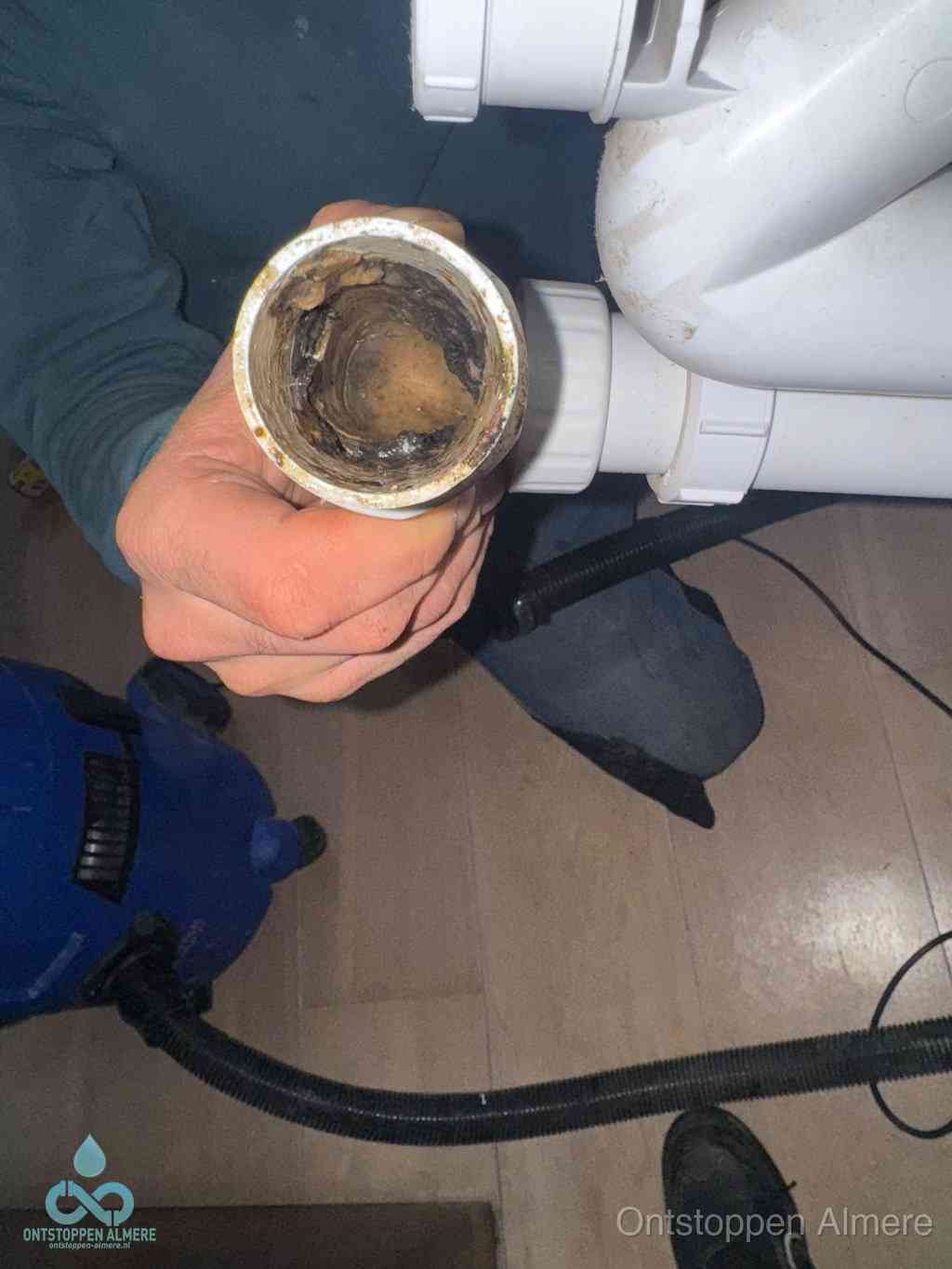 Een losgekoppeld afvoerbuisstuk dat van binnen volledig is dichtgeslibd, het gevolg van een verstopping te lang laten zitten in Almere