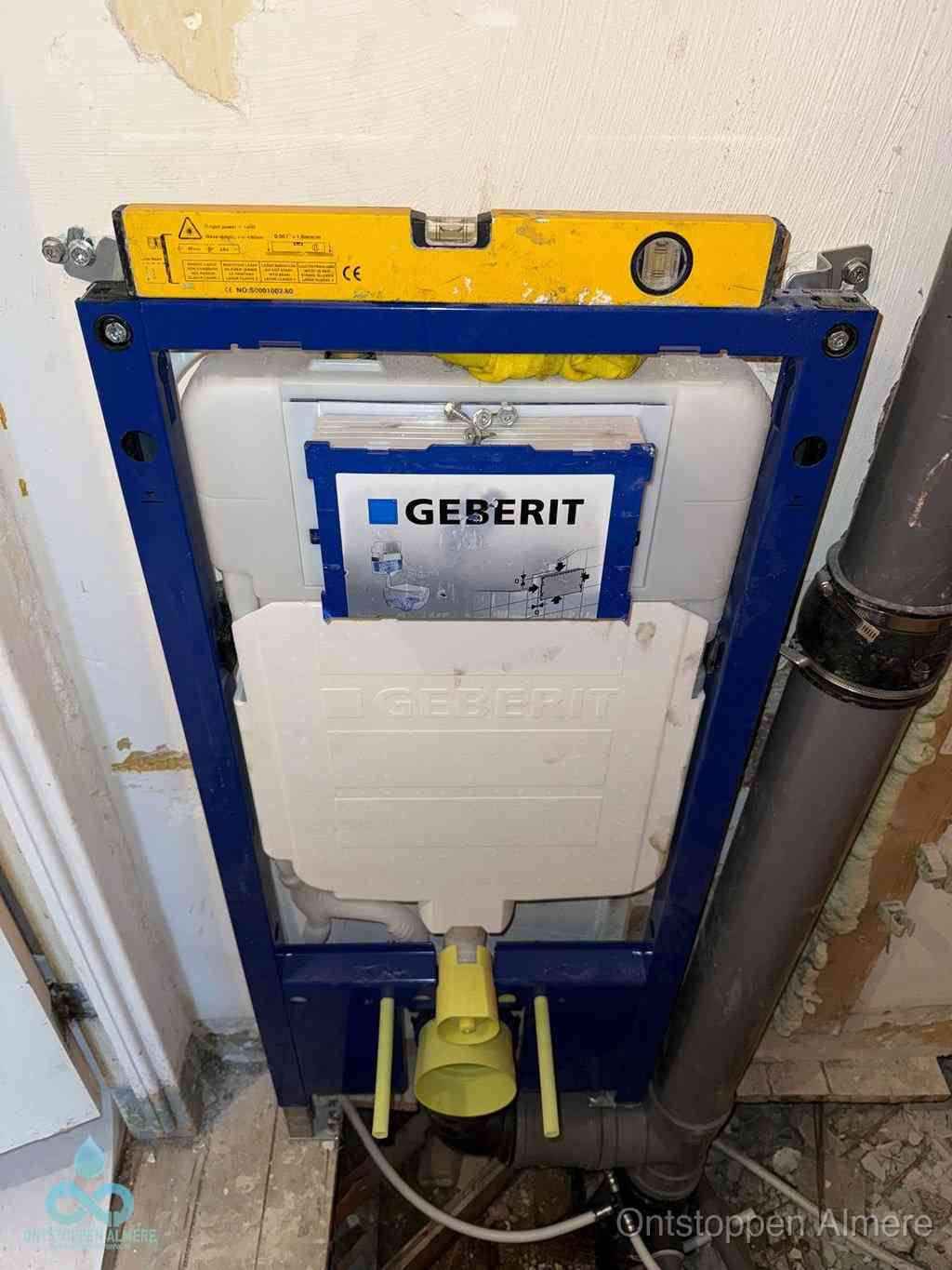 Een Geberit inbouwreservoir met frame voor een hangtoilet tegen de wand, met de afvoerbocht naar de vloer, kenmerkend voor een verstopt hangtoilet in Almere