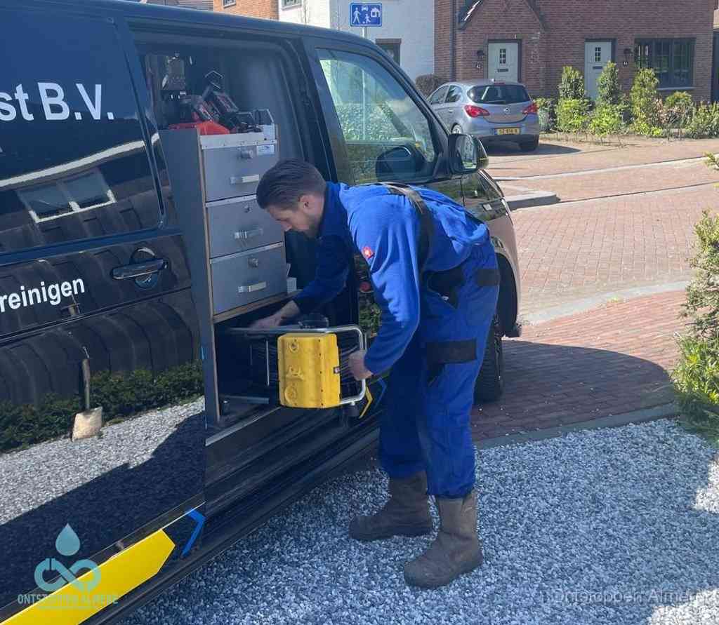 Een monteur pakt apparatuur uit de bedrijfsbus voor service aan huis, het moment om een professional in te schakelen voor een verstopte wc in Almere