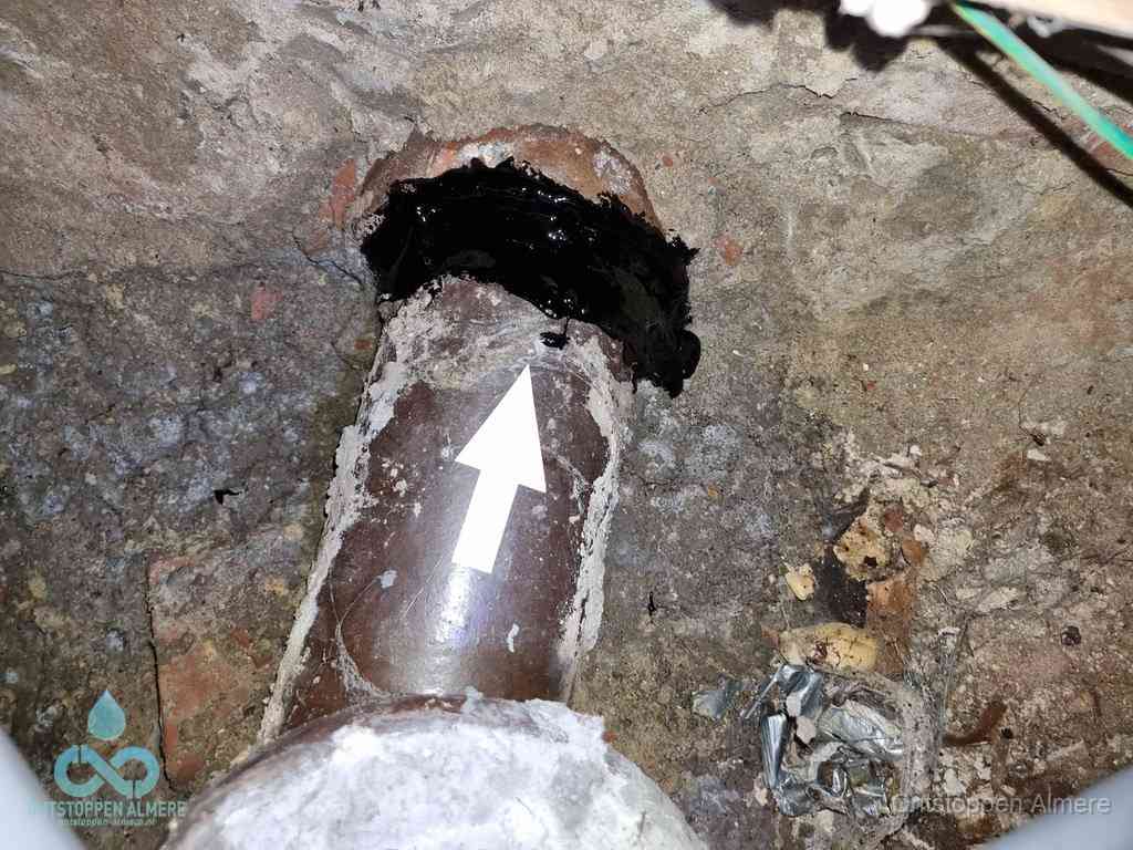Een oude gres rioolbuis met een beschadigde koppeling onder de vloer, oorzaak van terugkerende structurele wc-problemen in Almere