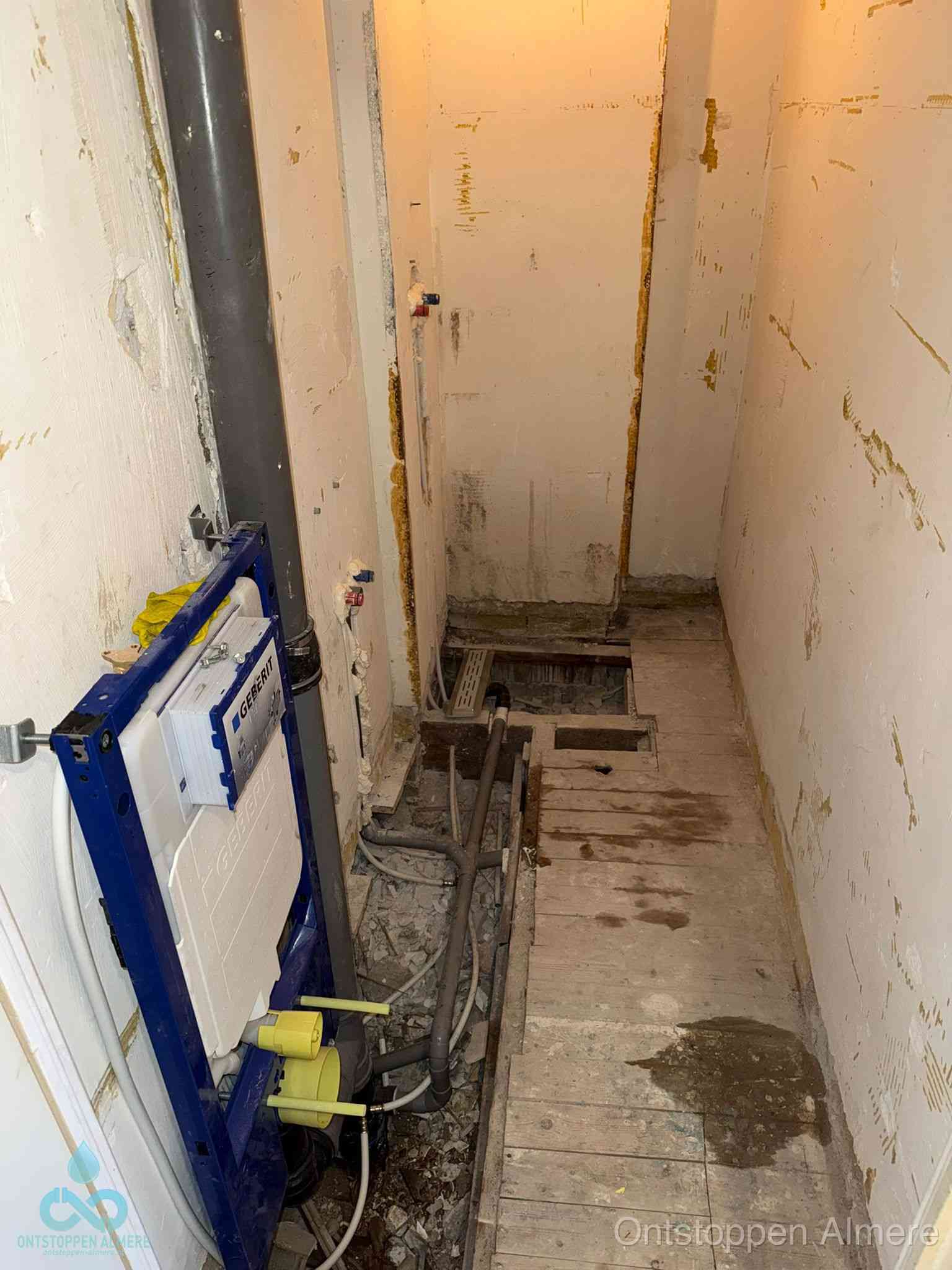 Een opgebroken toiletruimte tijdens renovatie met een Geberit inbouwreservoir en blootliggende oude afvoerleidingen, typisch voor oudere woningen in Almere
